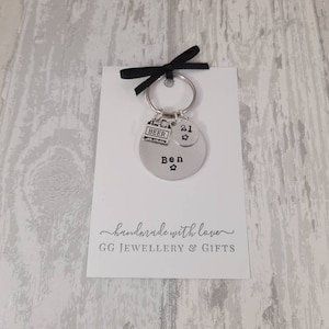 May include: A silver keychain with a round charm that says "Ben" with a star, a charm that says "21" with a star, and a charm that says "Beer". The keychain is on a white card with the text "handmade with love GG JEWELLERY & GIFTS".