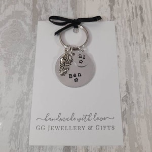 May include: Silver keychain with a football boot charm and a round tag that says "Ben 21" with a star. The keychain is on a white card with the text "handmade with love GG JEWELLERY & GIFTS".