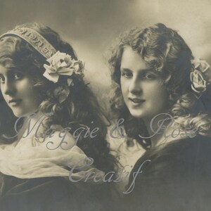 Könnte beinhalten: Vintage Schwarzweißfoto von zwei jungen Frauen mit langen, lockigen Haaren. Eine Frau trägt ein Stirnband mit dem Text "1918" darauf. Die andere Frau trägt eine Blume im Haar. Das Foto ist verblasst und hat einen Vintage-Look.