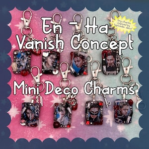 May include: A collection of rectangular charms featuring portraits of individuals, each attached to a silver-toned lobster clasp. The charms are decorated with small red and clear rhinestones, miniature metal blades, and heart shapes. Text reads: En-Ha Vanish Concept Mini Deco Charms.