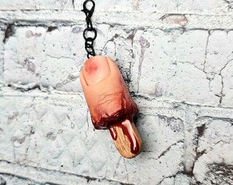 Gory thumb pop charm