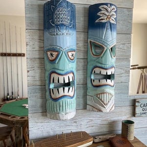 Tikis hawaianos de tortugas marinas y palmeras, tallados y pintados a mano en madera de teca ligera.