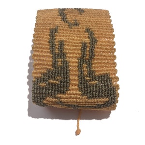 May include: A woven bracelet with a brown and tan pattern. The bracelet is made of string and has a fringe on the end.
