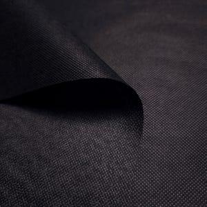 May include: Close-up of a textured black fabric with a subtle woven pattern. The fabric is folded over, revealing a dark, shadowed interior. The material appears durable and opaque, suitable for various crafting or design projects.