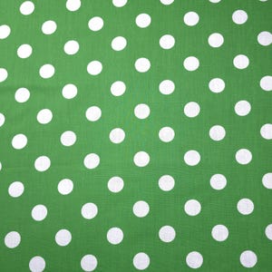 May include: Green fabric with a pattern of evenly spaced white polka dots. The dots are circular and of a uniform size, creating a playful and classic design. The fabric has a smooth texture and a vibrant color.