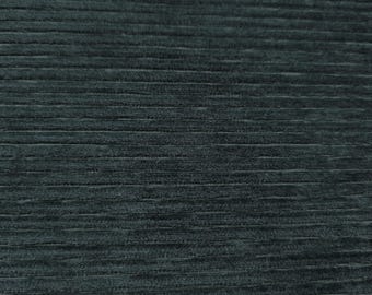 May include: A close-up shot of dark teal corduroy fabric. The fabric features a ribbed texture with horizontal lines. The colour is a deep, muted teal, with slight variations in tone across the surface.