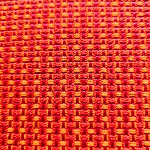 May include: A tightly woven textile fabric featuring a vibrant, repeating pattern of intersecting red and orange threads. The material displays a distinct grid-like texture created by the alternating horizontal and vertical weave of the colored fibers.