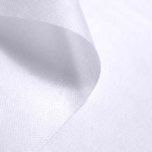 May include: Close-up of a white, textured fabric with a subtle weave pattern. The fabric is folded, creating soft curves and shadows. The overall impression is clean and minimalist, with a focus on the material's texture and form.