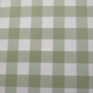 May include: A fabric featuring a classic gingham pattern with alternating squares of sage green and white. The textile displays a consistent, repeating checkered design across the entire surface, showcasing a woven texture with clean, straight lines.