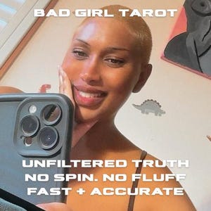 May include: Image featuring a person holding a phone, with text that reads "BAD GIRL TAROT" and "UNFILTERED TRUTH, NO SPIN. NO FLUFF, FAST + ACCURATE." The person is smiling, and the background includes a wall with a dinosaur sticker.