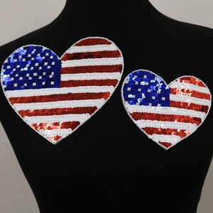 May include: Two heart-shaped patches with the American flag design. The patches are made of red, white, and blue sequins.