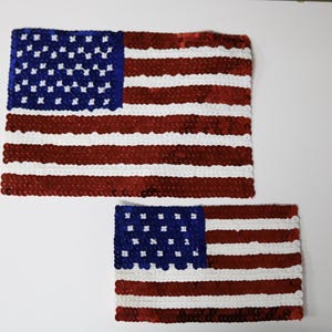 May include: Two American flag patches made of red, white, and blue sequins. The larger patch is about twice the size of the smaller patch.