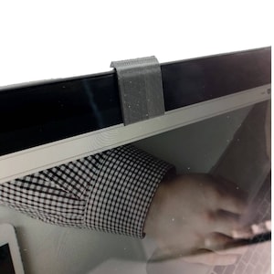 以下が含まれることがあります： ラップトップ用の黒いウェブカメラカバー。カバーはプラスチック製で、表面にテクスチャがあります。プライバシーを保護するために、ウェブカメラレンズの上にスライドするように設計されています。