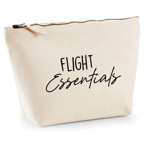 May include: A beige canvas zippered pouch with the text "FLIGHT Essentials" in black script.