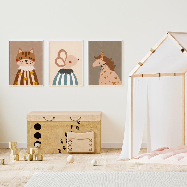 May include: Three framed art prints featuring whimsical animal illustrations: a cat, a mouse, and a unicorn. The cat wears a striped cape, the mouse a striped shirt, and the unicorn is adorned with stars. A wooden toy chest and play tent are also visible.