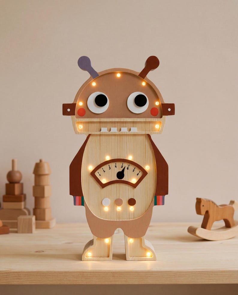 May include: A wooden robot-shaped night light with a light brown body, brown accents, and a light-up face. The robot has large black eyes, a meter-like display, and small lights around the head and feet. A fun, decorative item for a child's room.
