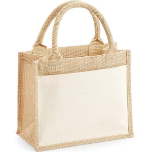 Puede incluir: Una peque&ntilde;a bolsa de mano de yute de color natural con un panel de lona blanca. La bolsa tiene dos asas resistentes y es perfecta para llevar objetos peque&ntilde;os.