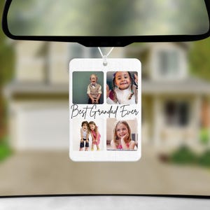 May include: A white rectangular car air freshener with four photo inserts and the text "Best Grandad Ever" in black script. The photos show children. The air freshener hangs from a car's rearview mirror.