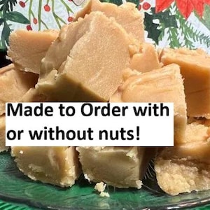 May include: A pile of light brown fudge squares on a green glass plate. The fudge has a slightly rough texture and appears to be freshly made. Text on the image reads "Made to Order with or without nuts!"