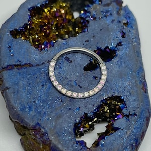 16 gauge 5/16 titanium hinged clicker with a row of 1.5mm AB/CZ gems. Think Septum Piercing