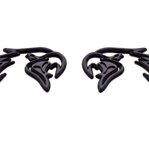 May include: A pair of black, stylized, abstract wings with a layered, 3D effect.