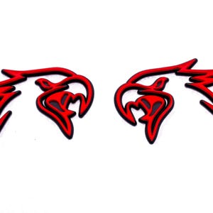 May include: Two red and black eagle head decals. The eagle heads are facing each other and have a 3D effect.