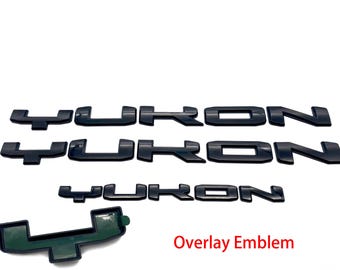 May include: Three black plastic "YUKON" emblems and a black plastic "4" emblem. Overlay Emblem.