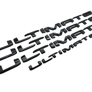 May include: Black, glossy "ULTIMATE" lettering in a stylized font. The letters are arranged in multiple rows, with the word repeated. The letters are three-dimensional and appear to be made of a hard material, possibly plastic or metal.