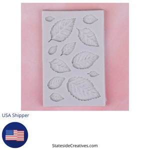May include: White silicone mold with 13 leaf shapes. The mold is designed for making fondant, gum paste, or chocolate decorations.