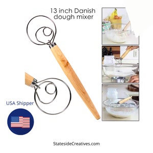 May include: A 13-inch Danish dough mixer with a stainless steel whisk and a light wood handle. The mixer is designed for mixing dough and has a spiral shape. The text "13 inch Danish dough mixer" is visible in the image.