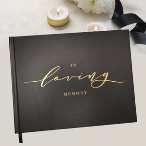 May include: Black hardcover memory book with gold lettering that reads "In loving memory".