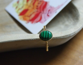Golden twisted ring with fine gold, black streaked green cabochons