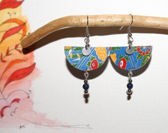 May include: A pair of handmade earrings with a half-circle design. The earrings feature a blue background with floral patterns in red, yellow, and green. Each earring has a silver-colored disc and a dangling cluster of dark blue beads. They hang from silver-colored hooks.