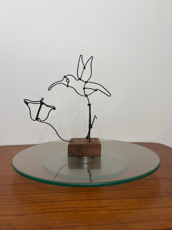 Hand-tied steel wire bent into a hummingbird mid-hover — a delicate, airy sculpture that's more gallery art than craft fair filler.
