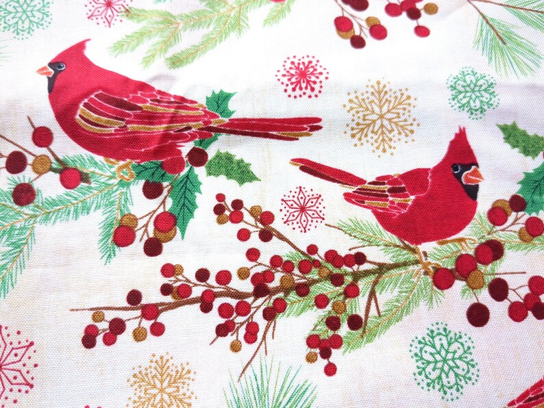 Tela de algodón de 44" x 70" con pájaros cardenales rojos sobre fondo beige, estampado navideño de invierno, acebo verde, pino y copos de nieve. imagen 6