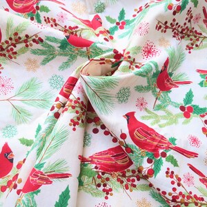 Tela de algodón de 44" x 70" con pájaros cardenales rojos sobre fondo beige, estampado navideño de invierno, acebo verde, pino y copos de nieve. imagen 3
