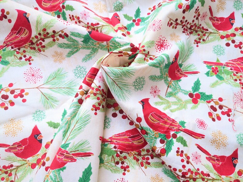 Tela de algodón de 44" x 70" con pájaros cardenales rojos sobre fondo beige, estampado navideño de invierno, acebo verde, pino y copos de nieve. imagen 3