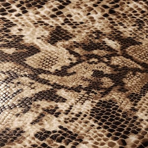 May include: Close-up of a fabric with a snakeskin pattern. The design features a repeating pattern of scales in shades of brown, tan, and black, creating a textured and realistic appearance. The overall effect is a blend of natural tones.
