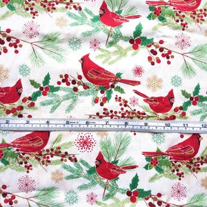 Tela de algodón de 44" x 70" con pájaros cardenales rojos sobre fondo beige, estampado navideño de invierno, acebo verde, pino y copos de nieve. imagen 8