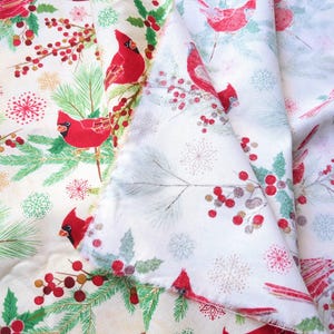 Tela de algodón de 44" x 70" con pájaros cardenales rojos sobre fondo beige, estampado navideño de invierno, acebo verde, pino y copos de nieve. imagen 4