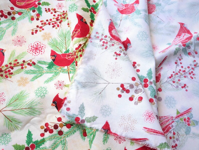 Tela de algodón de 44" x 70" con pájaros cardenales rojos sobre fondo beige, estampado navideño de invierno, acebo verde, pino y copos de nieve. imagen 4