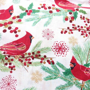 Tela de algodón de 44" x 70" con pájaros cardenales rojos sobre fondo beige, estampado navideño de invierno, acebo verde, pino y copos de nieve. imagen 1