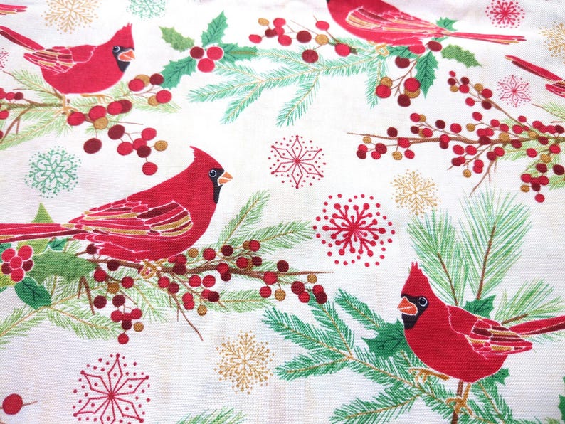 Tela de algodón de 44" x 70" con pájaros cardenales rojos sobre fondo beige, estampado navideño de invierno, acebo verde, pino y copos de nieve. imagen 1