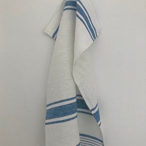 May include: White kitchen towel with blue stripes hanging on a hook.