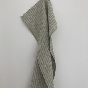 May include: A green and white striped linen kitchen towel hanging on a hook.