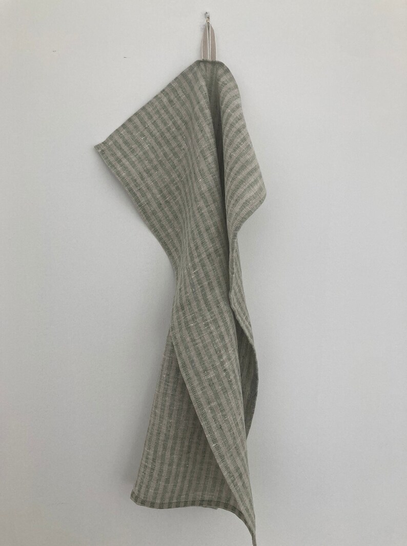 May include: A green and white striped linen kitchen towel hanging on a hook.