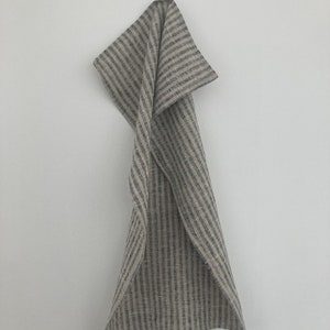 May include: A gray and white striped linen kitchen towel hanging on a hook.