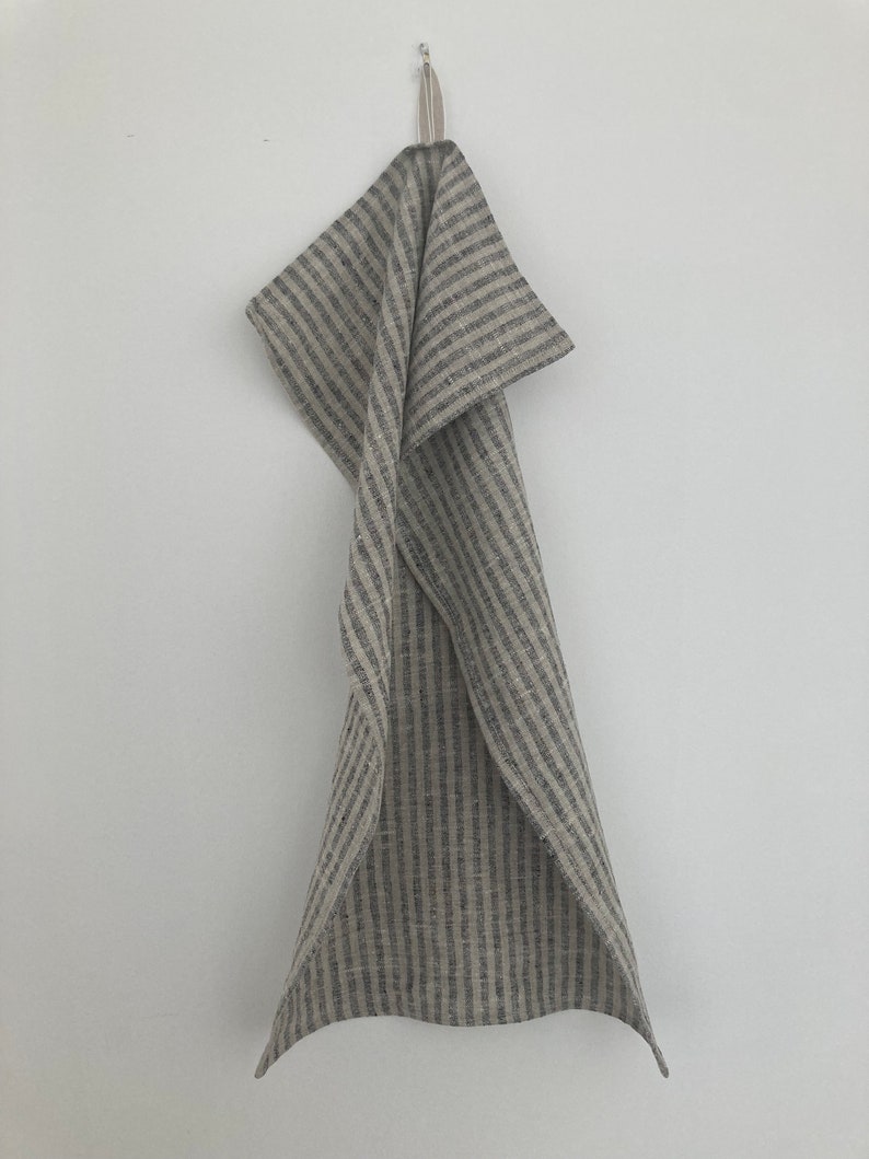 May include: A gray and white striped linen kitchen towel hanging on a hook.