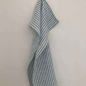 May include: A blue and white striped linen kitchen towel hanging on a hook.