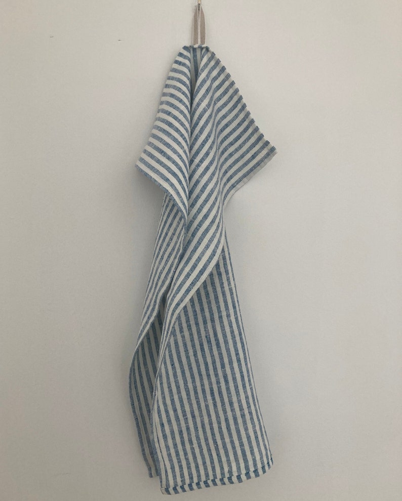 May include: A blue and white striped linen kitchen towel hanging on a hook.